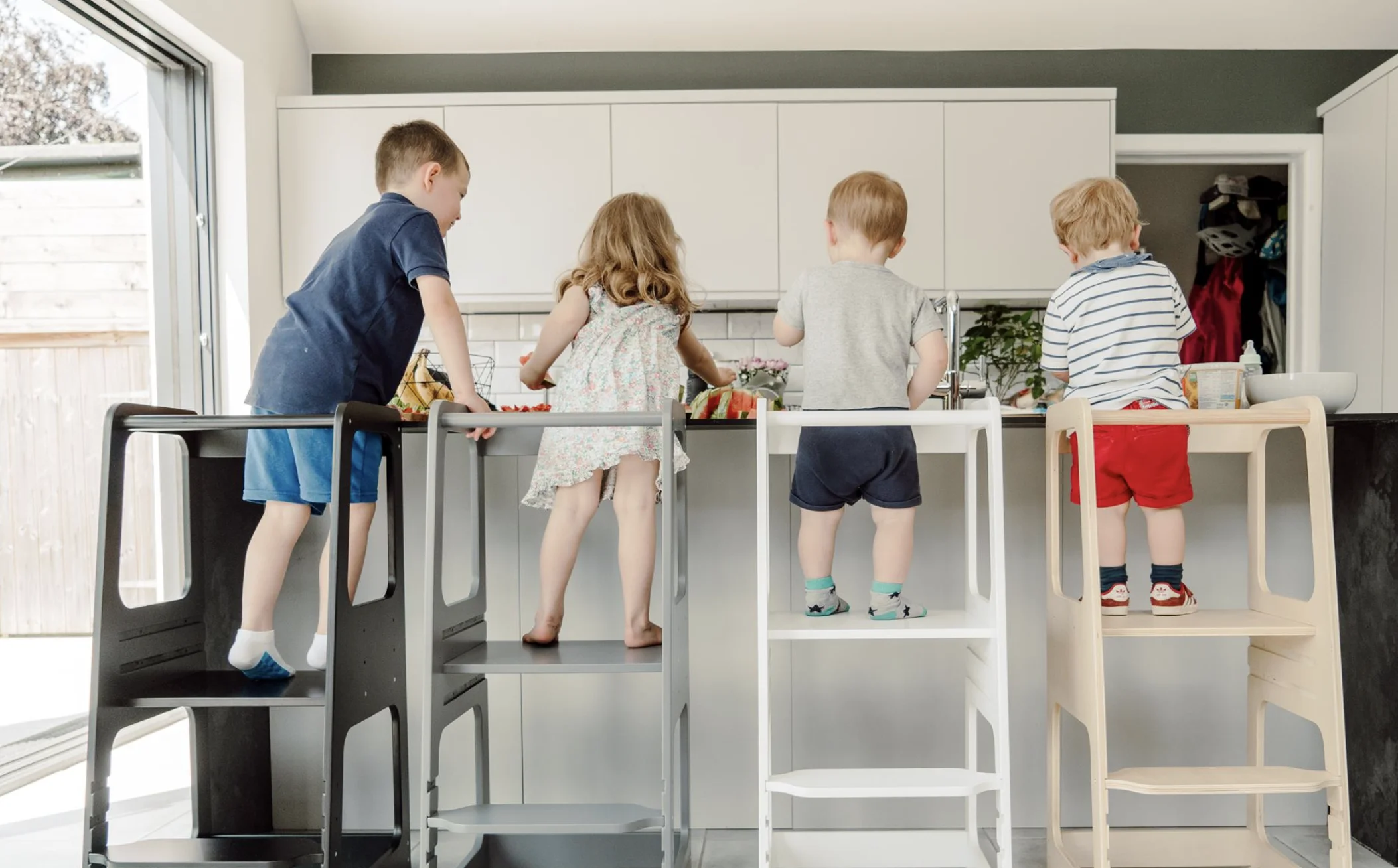 Kinderen op Montessori leertorens in de keuken